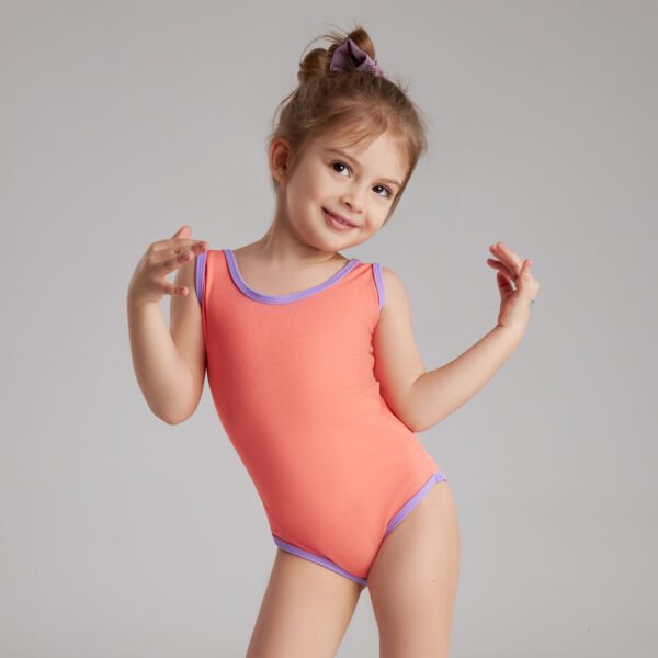 'Mini WISH' 5 A little girl in a pink bodysuit smiles and poses playfully for the camera.